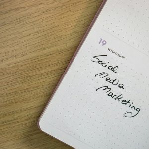 Close-up of a notebook page with 'Social Media Marketing' handwritten on it.