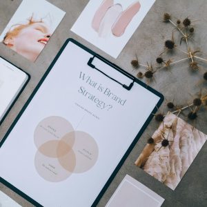 Overhead view of brand strategy documents with artistic visuals for business planning.